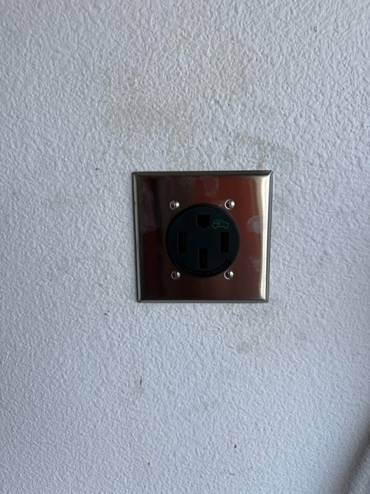 Finished 50-amp EV charging receptacle on an interior wall
